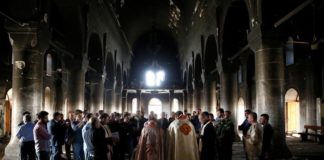 Iraqi priests hold the first Sunday mass at the Grand Immaculate Church since it was recaptured from Islamic State in Qaraqosh, near Mosul