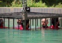 Captives inside a metal cage are lowered into a deep pool after they were condemned to die by an ISIS court for collaborating with enemy forces in Mosul.