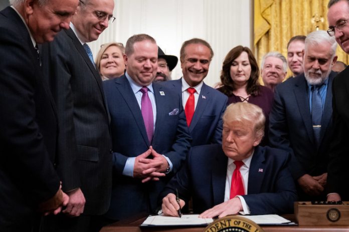 President Donald J. Trump signs H.R. 2476 the Securing American Nonprofit Organizations Against Terrorism Act of 2019, following his remarks at the Nation’s Mayors on Transforming America’s Communities meeting Friday, Jan. 24, 2020, in the East Room of the White House. | Official White House Photo/Tia Dufour