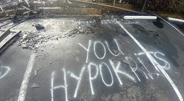 The graffiti in the parking lot reads: “Bet you stay home now you hypokrits 