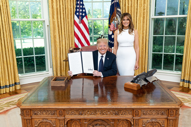 President Donald J. Trump, joined by First Lady Melania Trump, as he displays his signature after signing an executive order on strengthening the child welfare system for America’s children Wednesday, June 24, 2020, in the Oval Office of the White House. | White House/Shealah Craighead