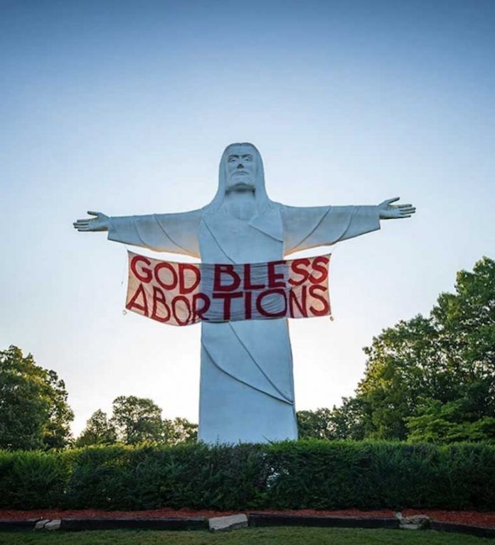 Indecline Activists Hung A "God Bless Abortions" Banner On Statue Of